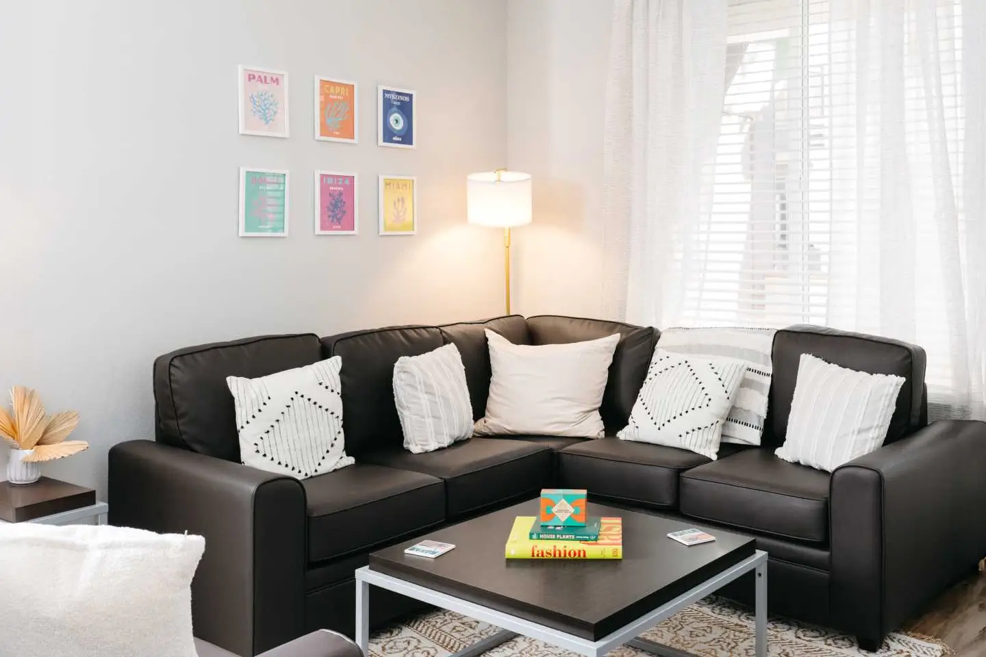 Living room space with sofa and coffee table with a large window behind it.