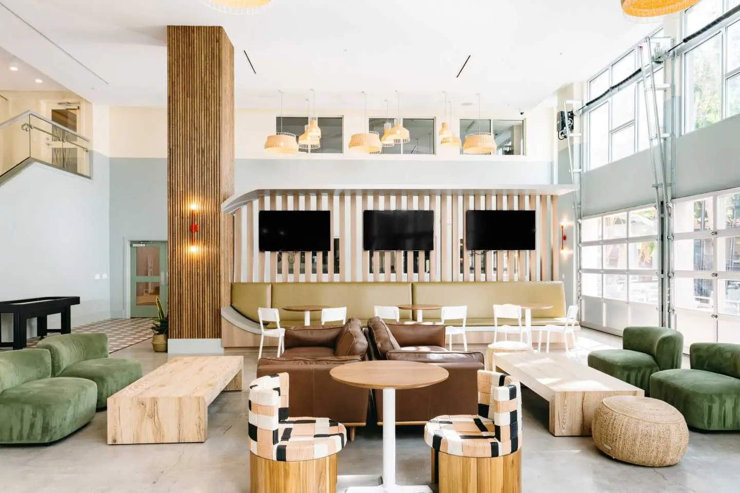 Large space with various forms of seating and TV's with lots of natural lighting.